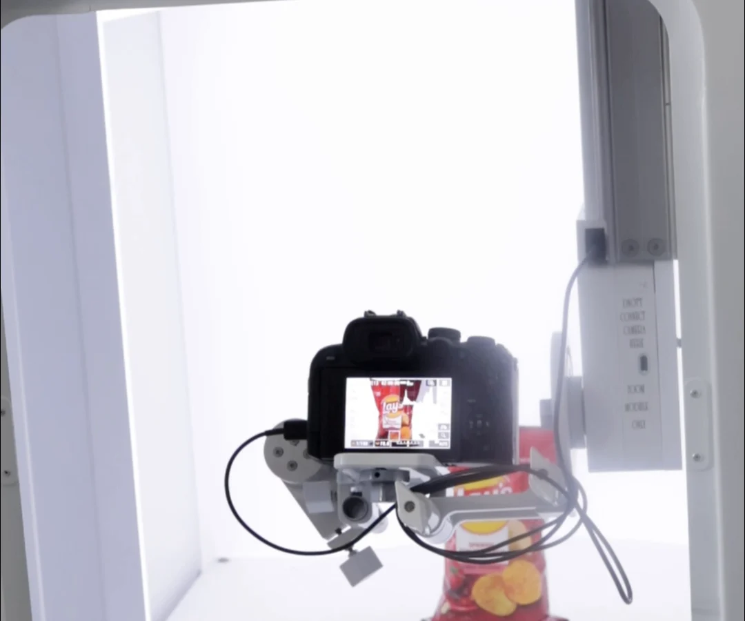A camera on its mount inside the EasyCLIQ X3, showing the Lay’s packet on its screen