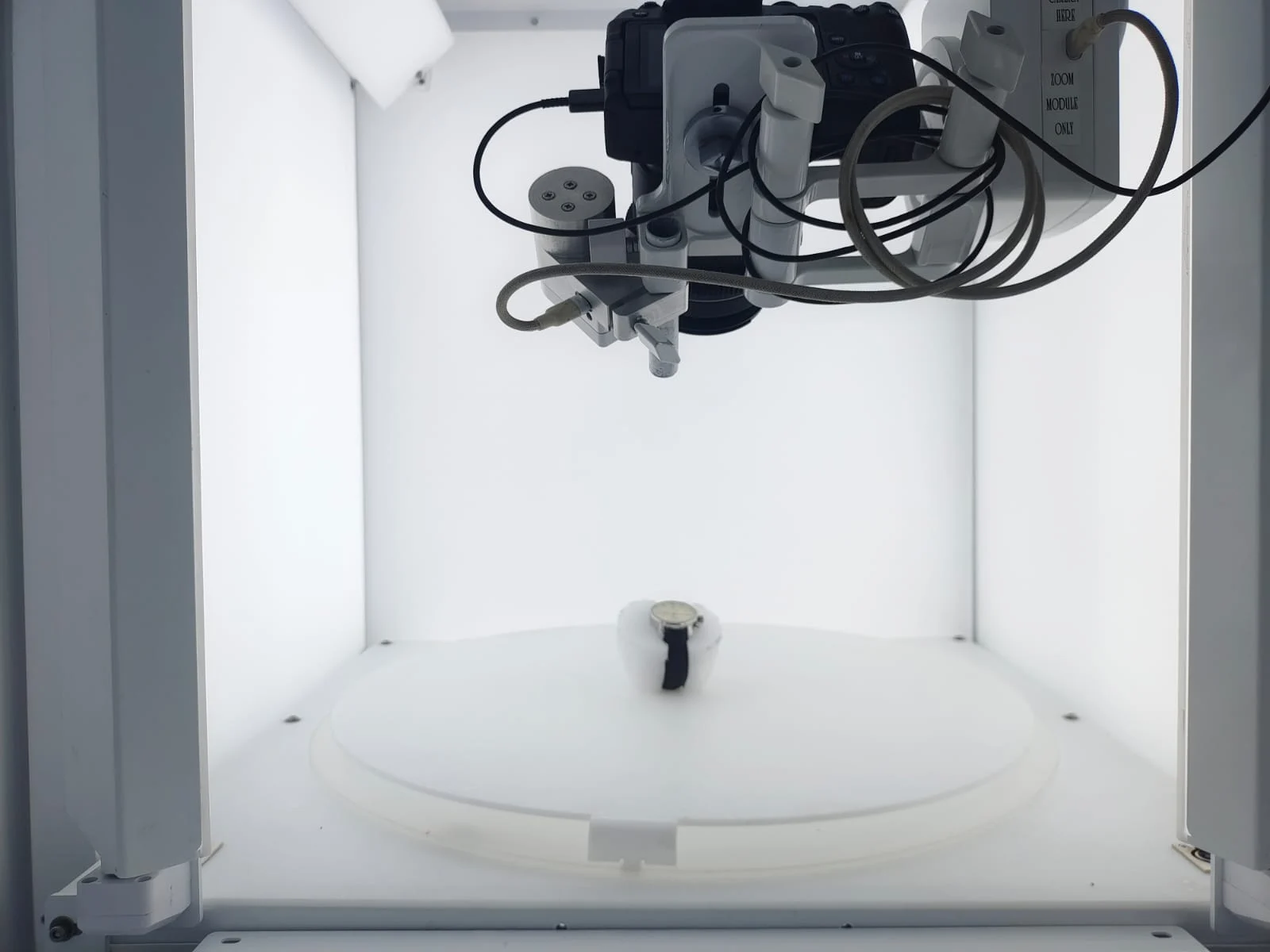 Inside an EasyCLIQ studio: the camera on its mount above the turntable, with a watch on a foam support