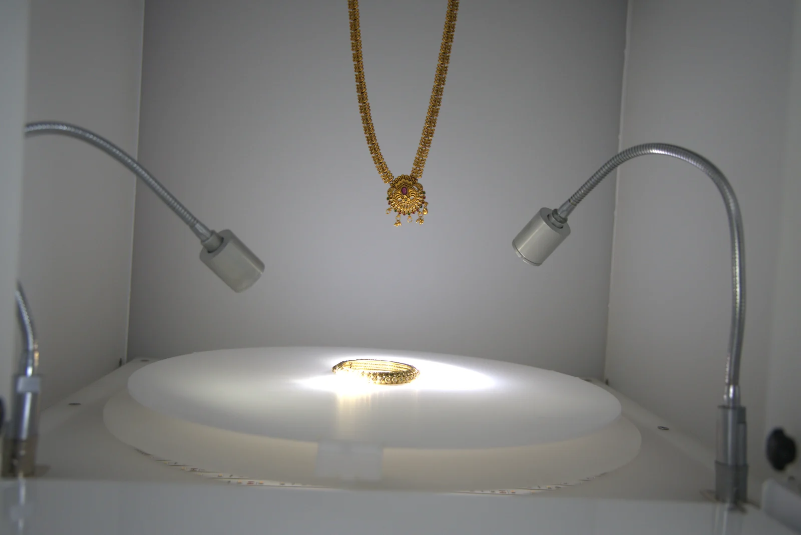 Inside the EasyCLIQ X3: LED panels and two focus lights around a gold necklace and a bangle on the turntable