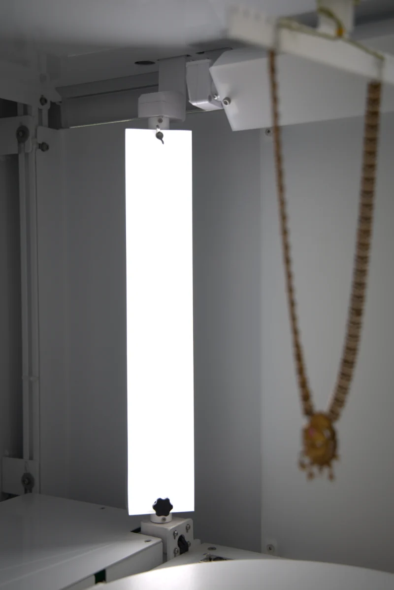 Diffused LED lighting for reflective product photography: a tall LED panel beside a gold necklace
